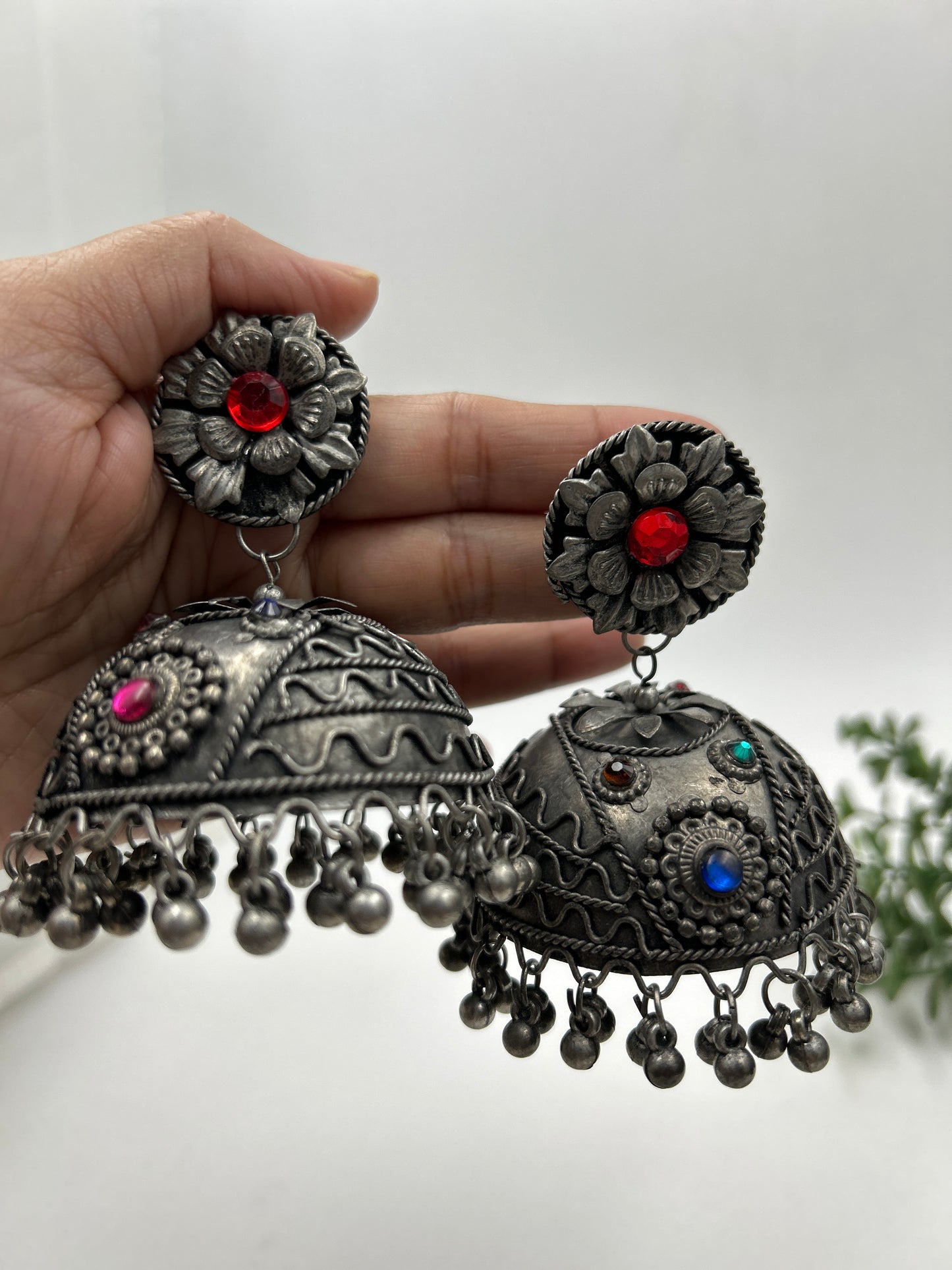 Bhavi black polished jhumka earrings shown in hand for size reference, featuring intricate design with no sound ghungroo hangings, bold ethnic statement jewelry