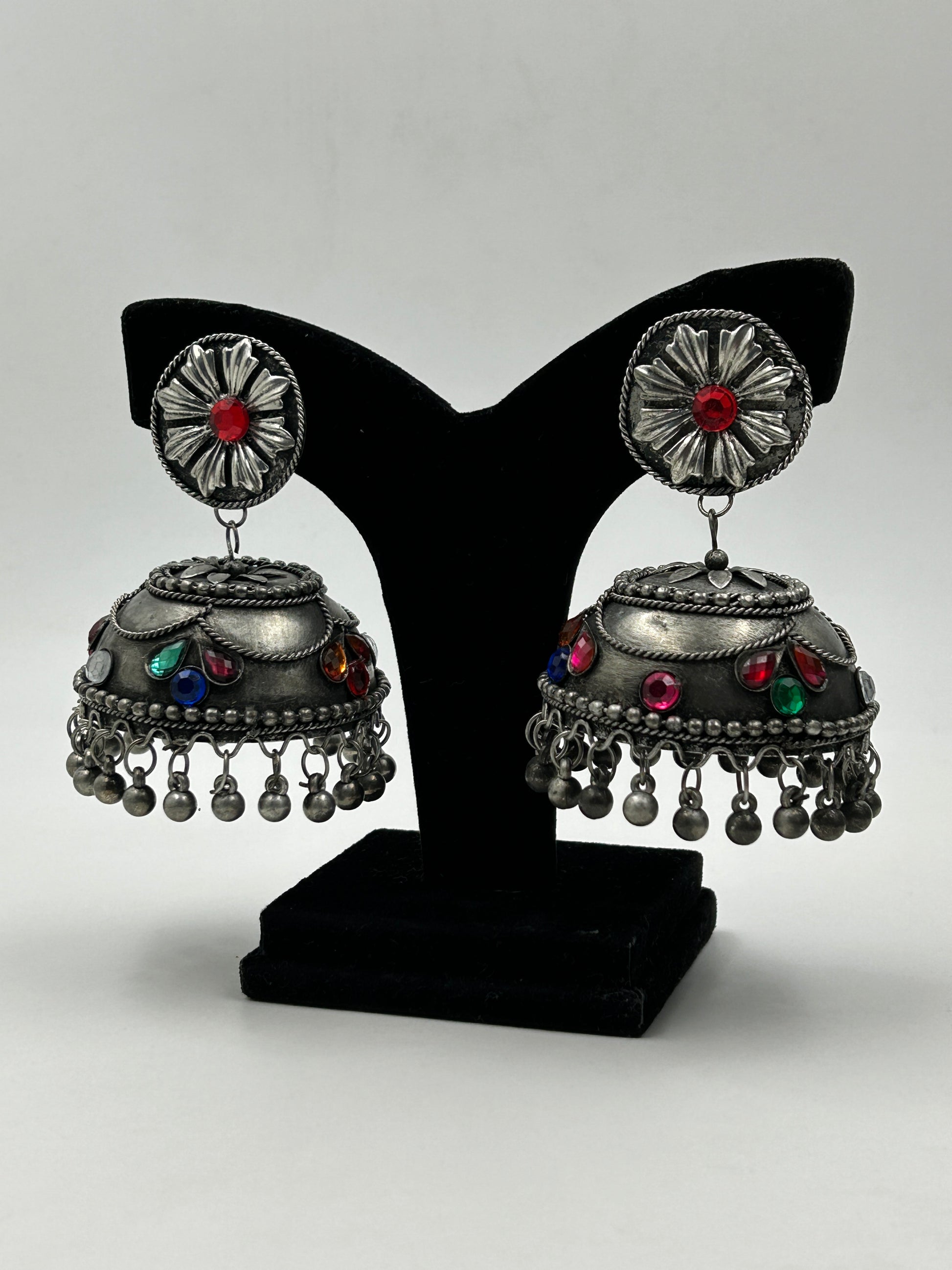 Banhi black polished jhumka earrings displayed on stand with detailed design and multicolor accents, featuring no sound hanging beads, bold ethnic statement earrings
