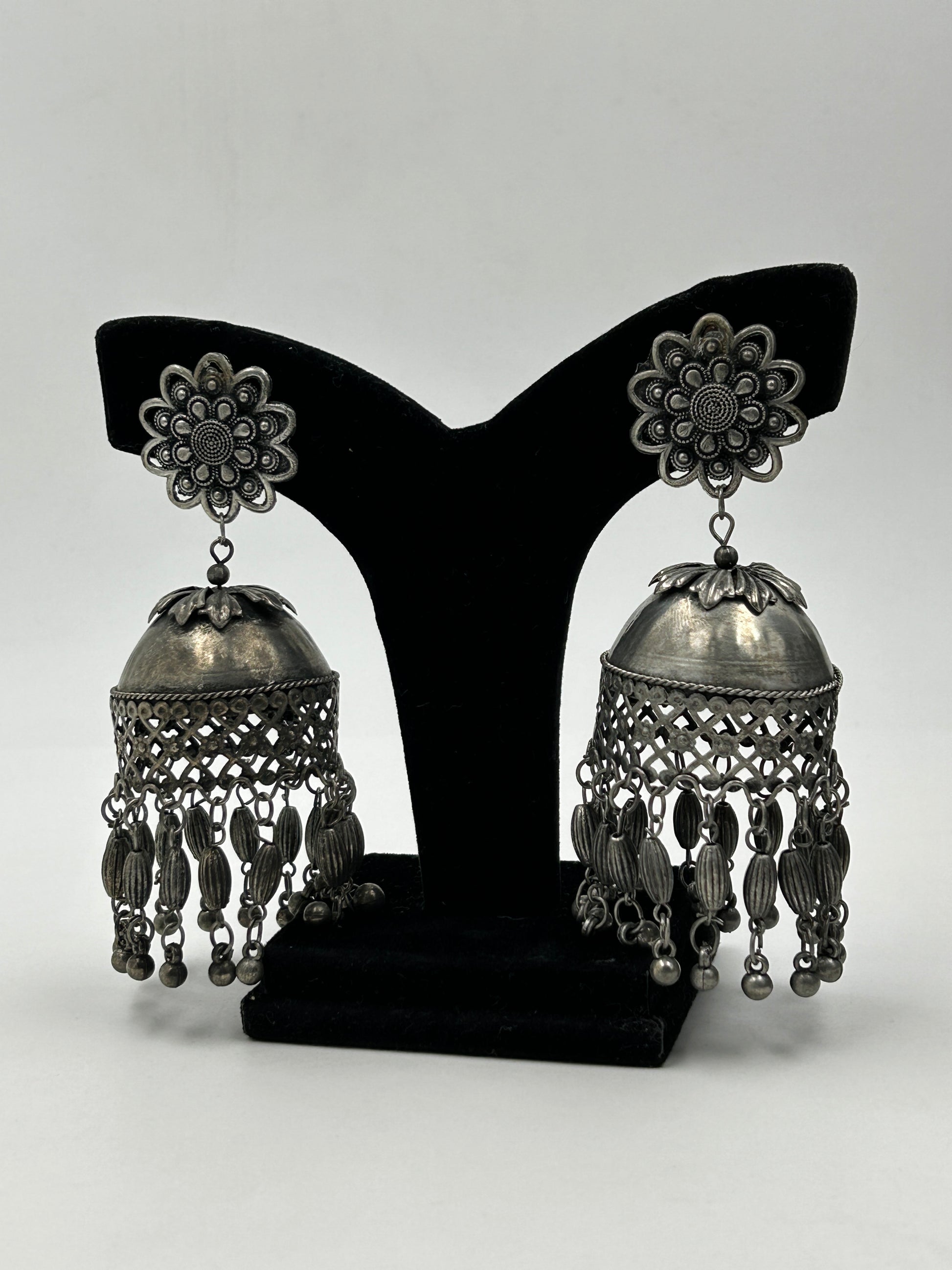 Darsha black polished jhumka earrings displayed on stand with floral stud and dome design, long tribal statement earrings for ethnic wear